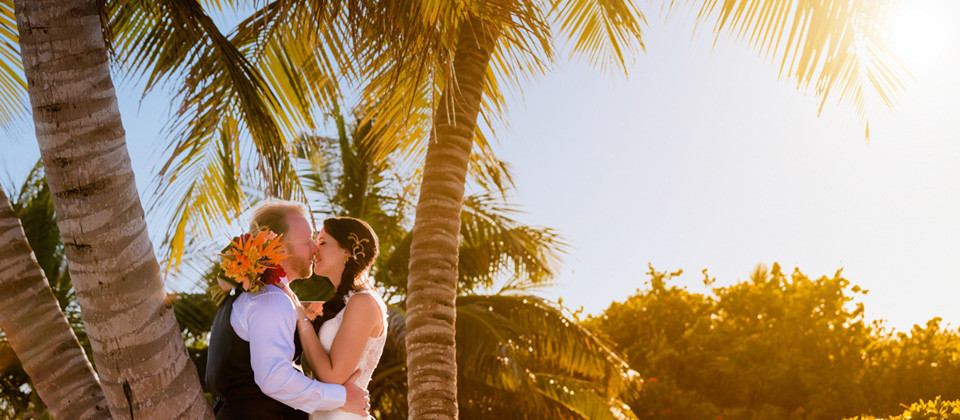 Couple kissing under palm tree