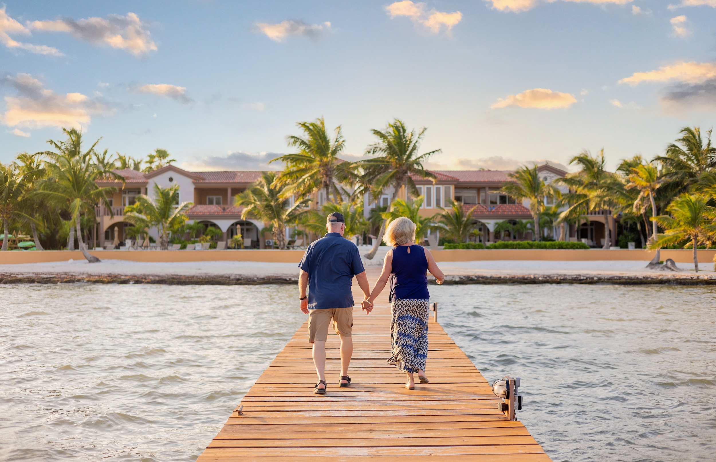 Couple walking on a dock overlooking the Caribbean Sea at Belizean Cove Estates