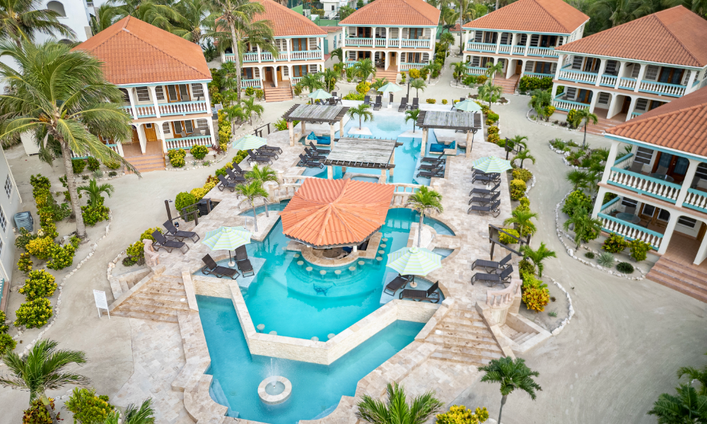Aerial view of the Belizean Shores Resort pool with swim-up bar and lounge chairs surrounded by two-story condo-style suites