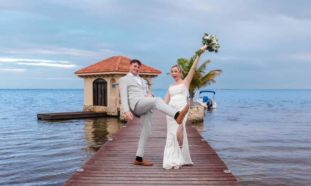 Bride and groom posing for wedding photos on the dock at Coco Beach Resort in Belize