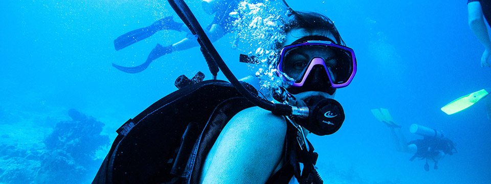 Scuba diver close-up with others in the background