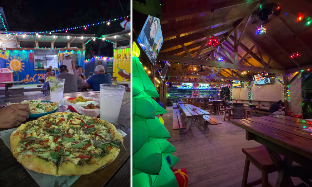 Pizza and drinks on picnic table at Truck Stop Belize with colorful food containers and covered dining area with string lights in background